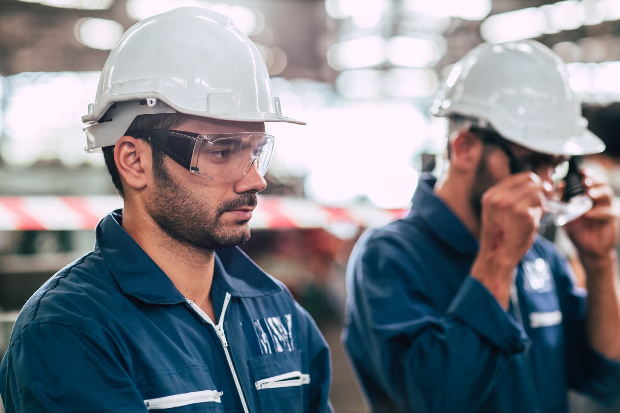 Engineers in hard hats and safety glasses on the factory floor